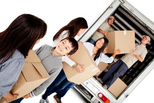 Front of a van parked on a West Kensington street with movers preparing equipment